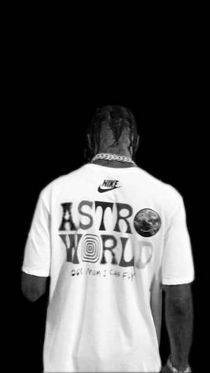 黑色背景上，穿著白色Astro World T恤並戴著鏈條的人的背面。