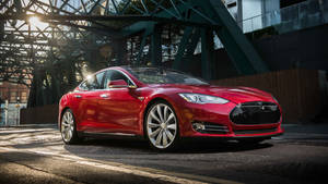 日落時分，紅色Tesla Model S停泊在鋼橋下。 — Tesla GIF 壁紙
