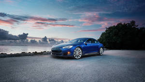 藍色Tesla Model S在日落時停泊在近水的礫石上。 — Tesla GIF 壁紙