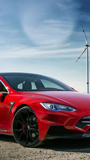 藍天下風力發電機附近的紅色Tesla汽車 — Tesla GIF 壁紙