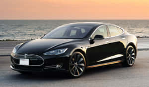 日落時分，黑色Tesla Model S停泊在海邊。