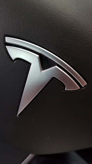黑色皮革汽車內飾上的時尚銀色 Tesla 標誌。