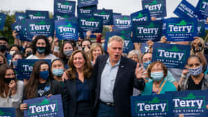 政治候選人Terry在維珍尼亞州的競選集會上，與舉著標語的支持者在一起。