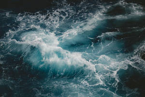 泡沫海浪在深藍色海水中衝擊。