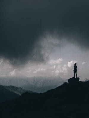 人在暴風雨天空下的山頂上站立。 — 雲朵 壁紙