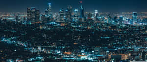 夜間城市景觀，摩天大樓燈火通明，城市燈光蔓延。