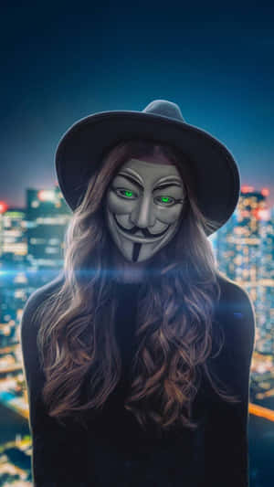 戴著蓋伊·福克斯面具和帽子的人俯瞰夜晚霓虹燈閃爍的城市。