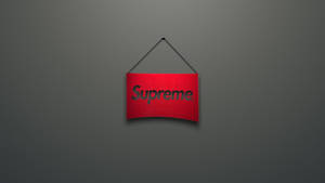 紅色Supreme品牌標誌懸掛在灰色牆壁上。