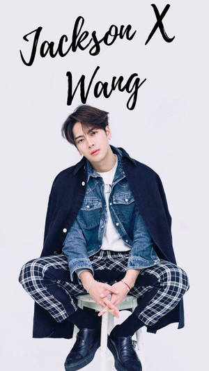 Jackson Wang 穿著多層次牛仔布和格子服裝，坐在白色攝影棚背景前。 — 成振宇 壁紙