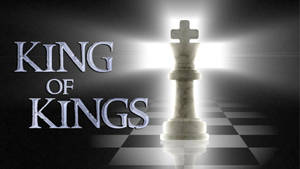 大理石國際象棋王被明亮光線照亮，在棋盤上帶有KING OF KINGS文字。