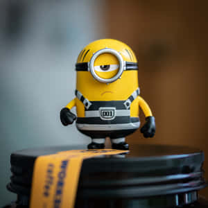 黃色Minion玩具公仔，有一隻眼，企喺黑色罐蓋上。