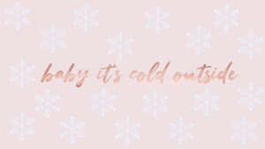 粉紅色牆紙，帶有白色雪花和玫瑰金色文字，寫著 baby it's cold outside。
