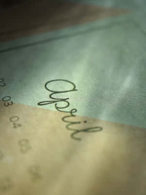 特寫「April」一詞，以草書寫在日曆頁上。