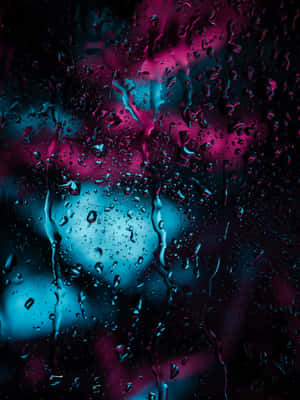 玻璃上的雨滴，背後有粉紅和藍色霓虹燈發光。