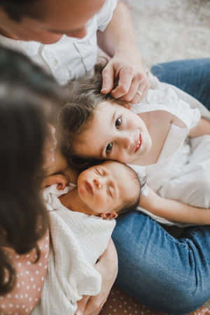 一位母親、父親和兩個孩子在舒適的室內環境中擁抱在一起。