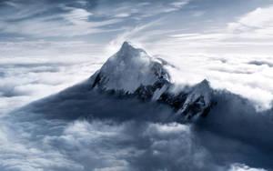 白雪覆蓋的山峰聳立在廣闊的雲海之上。