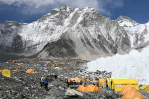 登山者和橙色帳篷在高海拔山區基地營，靠近冰川。