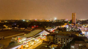 夜景，特色是明亮的交通站，周圍環繞著建築物。 — 夜景城市 壁紙