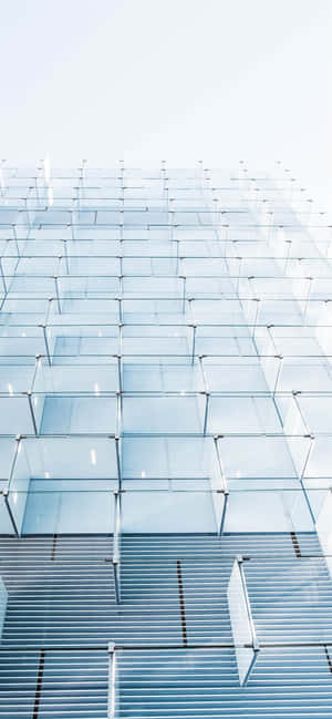 高聳的玻璃建築，帶有金屬格柵和反光面板，在日光下閃耀。 — Oppo A6t Pro 壁紙