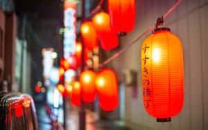 紅色紙燈籠照亮了一條狹窄的城市街道，夜晚伴隨著模糊的霓虹燈。