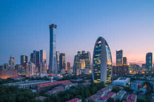 暮色城市景觀，燈火通明的摩天大樓和住宅建築。 — MacBook Air 15 壁紙