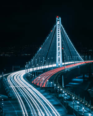 夜晚中發光的橋樑，帶有汽車的光跡。 — Apple Watch Ultra 壁紙