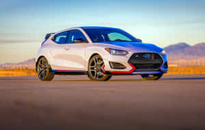 白色現代Veloster N跑車帶紅色點綴停在沙漠公路夕陽下。