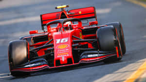 紅色法拉利F1賽車在日間比賽中在瀝青賽道上疾馳。