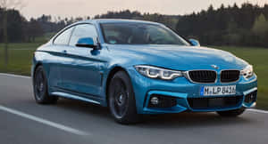 日落時分，藍色BMW雙門跑車在風景如畫的鄉間小路上行駛。
