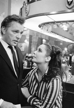 1960年代酒吧中一男一女進行激烈對話。 — 荷里活 GIF 壁紙