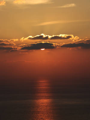 海上日落，有雲和水面上的金色倒影