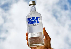 手拿Absolut Vodka酒瓶，背景陰天