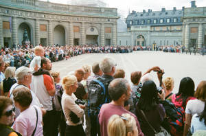 一群遊客聚集在歷史悠久的石頭庭院中。