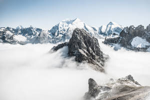 晴朗的日子裡，白雪覆蓋的山峰聳立在雲海之上。