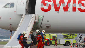 應急人員在停機坪上從瑞士飛機疏散乘客。