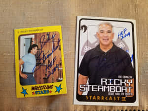 兩張簽名嘅Ricky Steamboat摔角交換卡喺米色布料背景上。 — 摔角 GIF 壁紙
