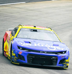 帶有Kroger標誌的藍黃色NASCAR賽車在賽道上疾馳。 — 汽車 壁紙