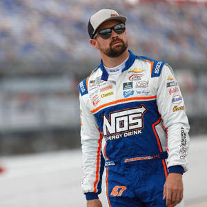 日落時分，NASCAR車手身穿賽車服站在賽道上