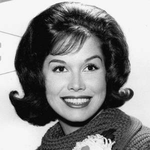 一位微笑的女性在復古黑白肖像中，戴著鉤針編織圍巾。