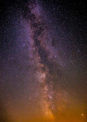 銀河系在漆黑的夜空中閃爍著星星和一顆流星。