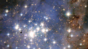 一個充滿活力的星場，有發光的星星和宇宙塵埃雲，呈現深藍色和橙色。 — 星空夜 壁紙