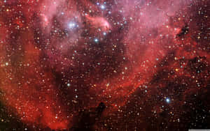 深空中充滿發光恆星和宇宙塵埃的鮮豔紅色星雲。