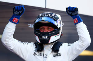F1車手以賽車裝備高舉拳頭慶祝勝利。