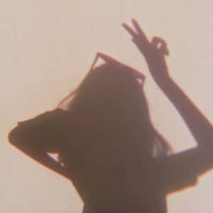 戴著太陽眼鏡的人影在牆上做出和平手勢。