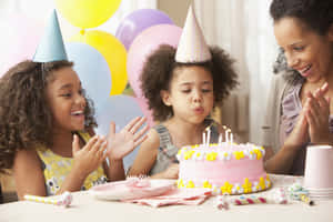 孩子們吹熄生日蠟燭，大人在附近拍手。