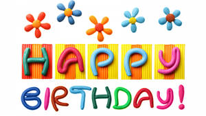 由色彩繽紛的黏土字母和花朵製成的Happy Birthday訊息。