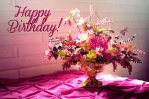 金色花瓶中的生日花束，粉紅色絎縫桌布，帶有「Happy Birthday!」文字。