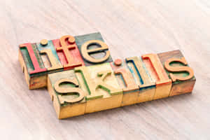 彩色木製活字塊在木頭上拼出 life skills。