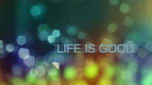 文字 life is good 喺色彩繽紛嘅抽象散景背景上。