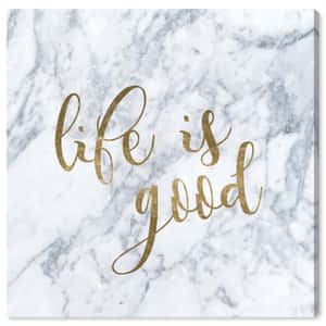 一塊大理石畫布，上面有金色字母寫著 life is good。